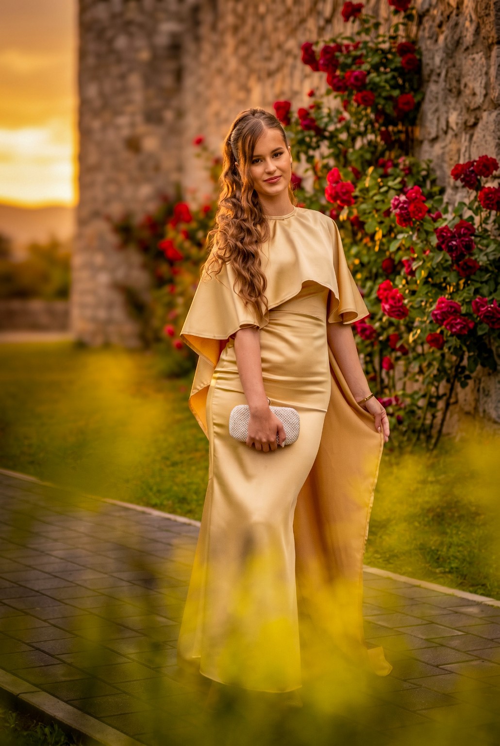 Portret u zlatnoj haljini pored crvenih ruža